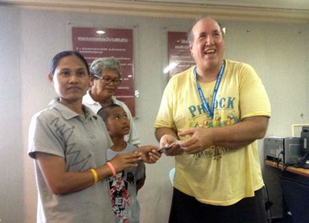 James Malanik (right) presents honest maid Yuphin Bunphet (left) with a reward for returning his lost bag, along with everything inside.