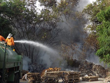 Firefighters work to bring under control a garbage fire off Thepprasit Road.