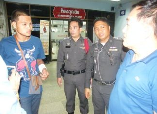 Phakorn Jittham (left) talks to police after receiving a gunshot wound from allegedly unknown assailants. His friend, Buncha Wonghong, was killed in the attack.