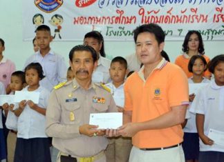 Manas Kongwattana (left), principal of Pattaya School No. 7, receives 20 scholarships, amounting to 20,000 baht, for the selected students from years 1-6 of the school.
