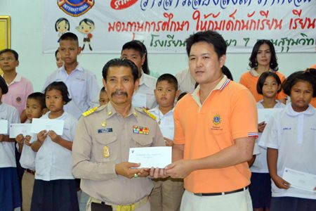 Manas Kongwattana (left), principal of Pattaya School No. 7, receives 20 scholarships, amounting to 20,000 baht, for the selected students from years 1-6 of the school.