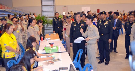 Col. Sirichai Distakul (center right), armed forces chief of joint staff and chairman of the Sub-Committee on Transnational Labor and Human Trafficking, inspects the registration process for foreign workers at Huay Yai’s one-stop center in the Eastern National Sports Training Center.