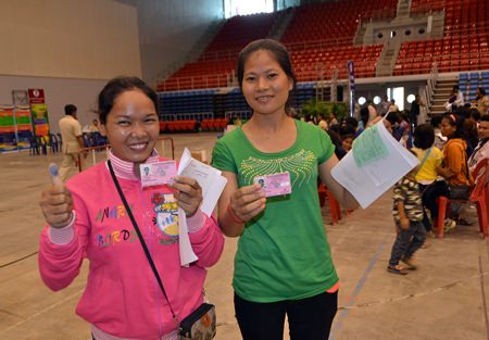 Two happy workers show off their new I.D. cards.