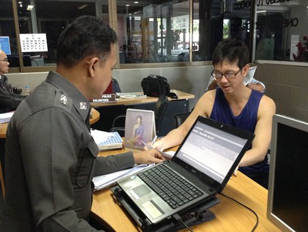 Krit Kanchanaprasan fills out a theft report with police.