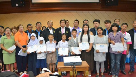 Deputy Mayor Ronakit Ekasingh awards eight scholarships of 500 baht each to students with grade-point averages above 3.5.