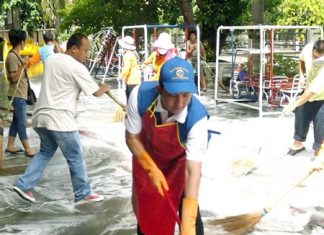 Mayor Itthiphol Kunplome grabs a mop and scrub brush to help wash the floor in front of the Wat Chaimongkol Nursery School, as more than 1,000 young Pattaya children were given checkups and city officials cleaned floors to help prevent new outbreaks of hand, foot and mouth disease.