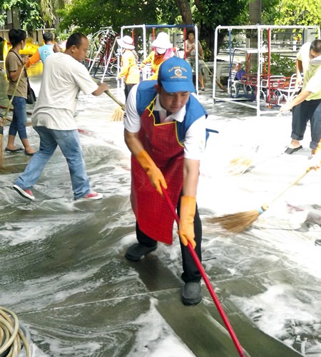 Mayor Itthiphol Kunplome grabs a mop and scrub brush to help wash the floor in front of the Wat Chaimongkol Nursery School, as more than 1,000 young Pattaya children were given checkups and city officials cleaned floors to help prevent new outbreaks of hand, foot and mouth disease.