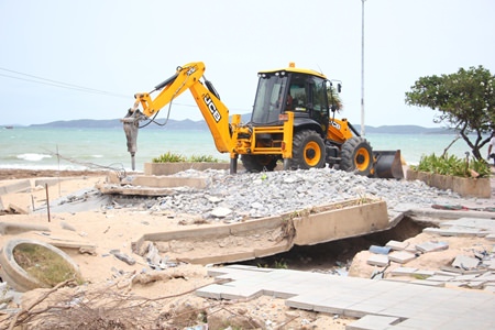 A city construction crew goes to work demolishing the damaged pavilion at Yin Yom beach.