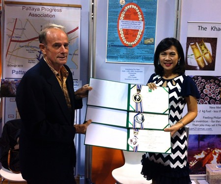Stuart is presented with the Gold, Silver and Bronze Medals for his inventions by Associate Professor Kosum Chansiri, of the Department of Biochemistry, Srinakarinwirot University.