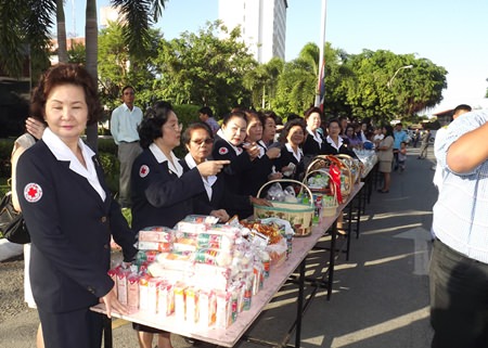 Red Cross members offer alms to monks on Mother’s Day in front of the Banglamung District Office.