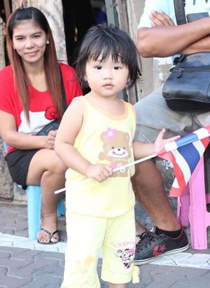 A little child waves the Thai flag.