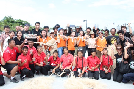 YWCA Chairwoman Praichit Jetpai (center) and YWCA members join members of the Naklua Bay Group, students, and local fishermen to make artificial grass from ropes to create seabeds to return balance to the aquatic environment.