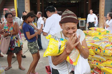 Disadvantaged Sattahip residents are thankful to receive rice handed out by Chinese-Thais wishing to brush away their demons.