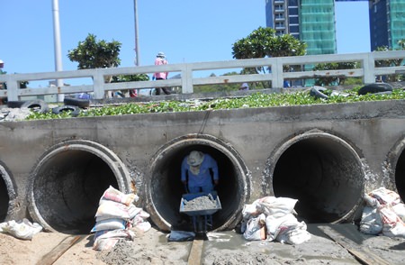 Sanitation Engineering Department staffers clean out sand and debris from flood water drainage pipes at Bali Hai Pier, part of the city’s ongoing effort to mitigate flooding when the heaviest rains hit in September and November. 