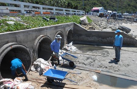 Sanitation Engineering Department crews clear sand, garbage and natural debris from the tail ends of the pipelines carrying flood water from eastern parts of the city.