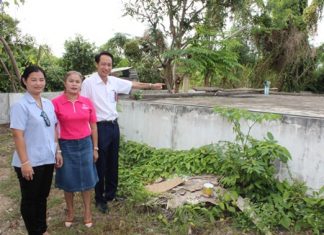 Vutikorn Kamolchote, President of Rotary Club of Jomtien-Pattaya, points towards the center’s water tank.