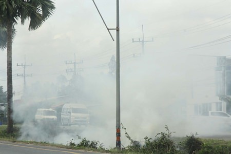 The crew burns cut grass and vegetation in a roadside ditch, causing poor visibility and creating some near misses.