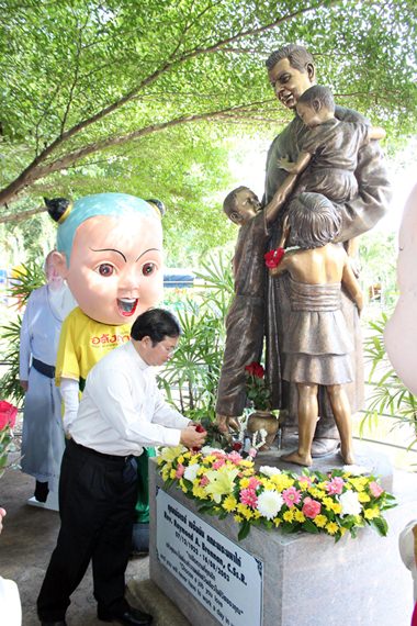 Father Michael Picharn Jaiseri lays roses before a statue of the revered founder.