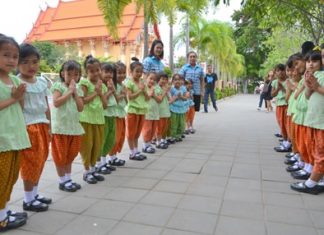 Young students welcome guests to the 59th anniversary of their school.