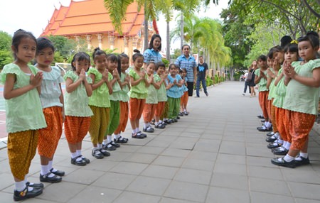 Young students welcome guests to the 59th anniversary of their school.
