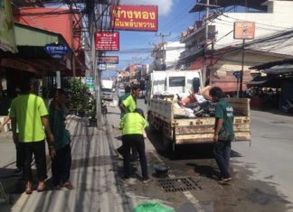 Nongprue Municipal Sanitation officers clean waste from sewage pipes. The back of the lorry is filled with refuse they dug out.
