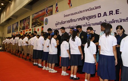 Politicians and teachers line up to present certificates to children who completed D.A.R.E. training this year.