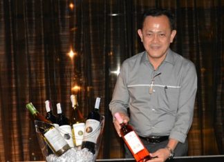 Teera Weerawan, National Sales Manager of Independent Wine & Spirit, displays a bottle of wine.
