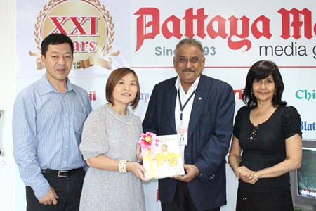 Pratheep Malhotra (2nd right) presents commemorative books published by the Pattaya Mail Media Group on Their Majesties the King and Queen to Suladda Sarutilavan, director of TAT Pattaya office. They are flanked by Auttapon Thaweesuntorn (left), Asst. Dir. TAT Pattaya office, and Sue Kukarja (right), Director of Communications of PMTV.