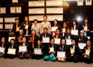 Mayor Itthiphol Kunplome (back row, center) presents awards to Pattaya’s most outstanding citizens and community groups for upholding royal values and working on behalf of society.