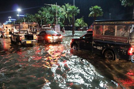 High winds and heavy rains slammed into Pattaya Saturday night, Oct. 11, knocking down trees and power lines, flooding a large part of the city, and leaving a tangled mess in its wake.  The storm hit the heaviest during “prime time” when weekend traffic was already at its worst.  Shown here, Beach Road Pattaya was nearly at a standstill as floodwaters ripped across the road towards the sea. 