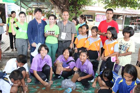 YWCA Chairwoman Praichit Jetpai (standing, 3rd left) along with YWCA members and guests teach students and teachers at Pattaya School No. 7 how to grow mushrooms.