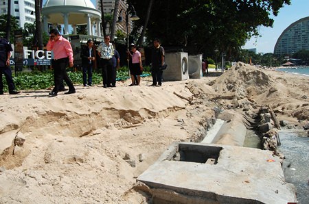 Officials inspect the area of Wong Amat Beach where heavy rain interrupted construction of new waste water pipes, causing sewage to empty into the sea.