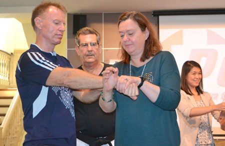 Jim Jones watches as members of the audience practice using pressure points for self defence.