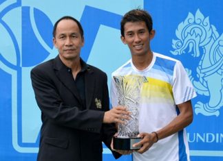 Singha representative Sruang Jantrautai (left) presents the crystal cut trophy to men’s champion Phassawit Burapharitta.