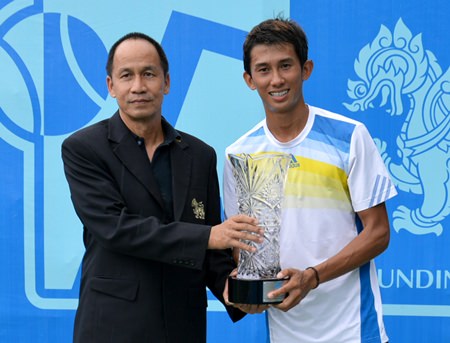 Singha representative Sruang Jantrautai (left) presents the crystal cut trophy to men’s champion Phassawit Burapharitta.