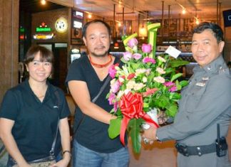 Pol. Col. Dhamnoon Munkong (right), Superintendent of the Banglamung Police Station, presents flowers to the management team of Café de Beach during the soft opening ceremony.