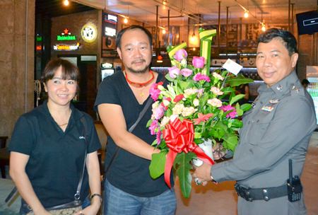 Pol. Col. Dhamnoon Munkong (right), Superintendent of the Banglamung Police Station, presents flowers to the management team of Café de Beach during the soft opening ceremony.