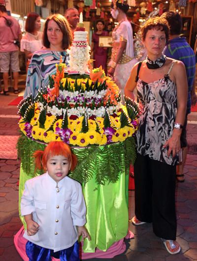 Tourists stroll along, looking at beautiful krathongs on Walking Street.
