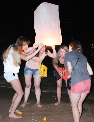 Foreign teenage girls float lanterns together.