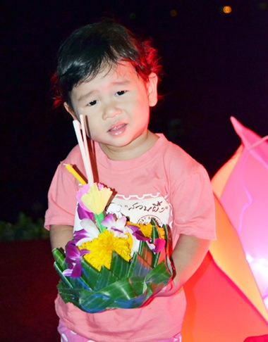 A boy poses before floating his krathong.