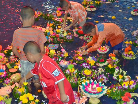 Children look for money from inside the krathongs.