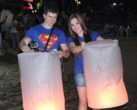 A foreign “super” couple lets go of a lantern for good luck.