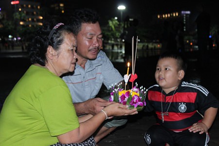 A family makes a wish before floating their krathong into the sea at Pattaya Beach Soi 4.
