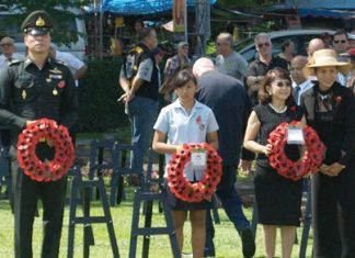 A GIS student carries a wreath at a service in Kanchanaburi.