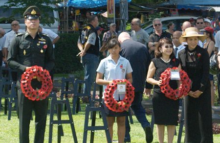 A GIS student carries a wreath at a service in Kanchanaburi.