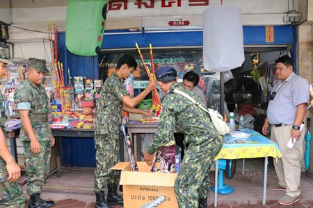 District Chief Phawat Lertmukda (right) leads a team of volunteers, police and navy personnel through the Sattahip Market raiding vendors selling firecrackers and khom loys.