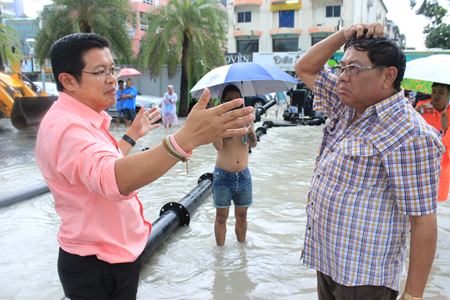 Deputy Mayor Verawat Khakhay and Sanitation Engineering Department director Wirat Jeerasreephaibhul inspect the flooding situation, and how well the pumps were, or weren’t, working across from Pattaya Soi 6.