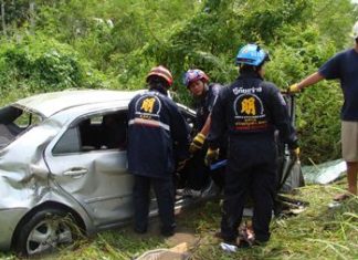 Experts work to extricate the victims after their car was struck by a State Railway of Thailand train at an unmarked crossing in Nong Sadao in Banglamung District.