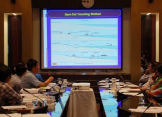 Officials look over a plan for new, wider drainage pipes, for which, evidently, Pattaya coffers don’t have the funds.
