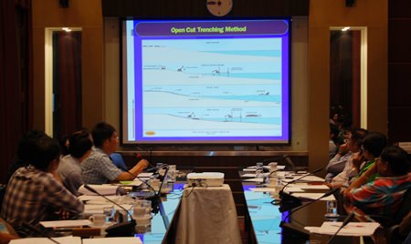 Officials look over a plan for new, wider drainage pipes, for which, evidently, Pattaya coffers don’t have the funds.